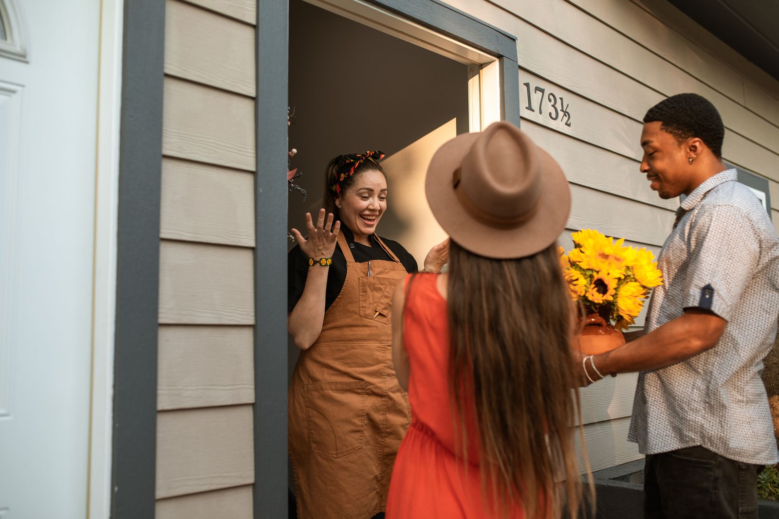 Une hôtesse accueille ses amis sur le pas de sa porte